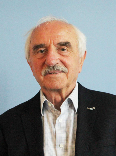 Porträt eines älteren Mannes mit weißen Haaren, Schnurrbart und einem Segelflugzeug-Anstecker am Sakko.
