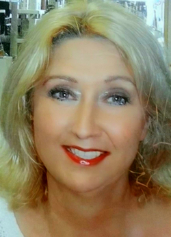 Lächelnde Frau mit blonden Haaren, rotem Lippenstift und Augen-Make-up in einem hellen Porträt.