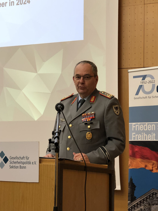 General Carsten Mais in Militäruniform spricht an einem Rednerpult bei einer Veranstaltung der Gesellschaft für Sicherheitspolitik.