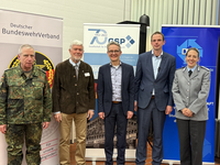 Fünf Personen, darunter Militärangehörige, posieren für ein Foto vor Bannern des Deutschen BundeswehrVerbandes und GSP.