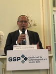 Prof. Dr. Friedrich Kießling spricht an einem Rednerpult mit Mikrofon, ein GSP-Schild ist sichtbar.