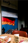 Banner der GSP (Gesellschaft für Sicherheitspolitik) mit deutscher Flagge, Motto "Frieden sichern Freiheit bewahren", Trauben und Käse.