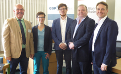 Fünf lächelnde Personen stehen nebeneinander vor Bannern einer Veranstaltung mit den Logos GSP und Atlantik.