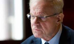 Nahaufnahme des ehemaligen dänischen Premierministers Poul Nyrup Rasmussen, ein Mann mit weißem Haar und Brille, blickt nach links.