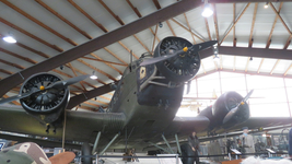 Eine Junkers Ju 52, ein dreimotoriges Flugzeug mit Wellblechverkleidung, ausgestellt in einem Museumshangar.