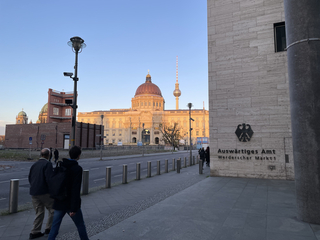 Deutsches Auswärtiges Amt, beleuchtetes Humboldt Forum und Berliner Fernsehturm unter blauem Himmel zur goldenen Stunde.