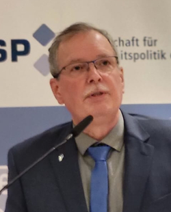 Mann Radig spricht auf einem Konferenzpodium mit GSP-Banner und Atlantic Hotel Schild im Hintergrund.
