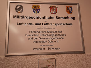 Schild: Militärgeschichtliche Sammlung der Luftlande- & Lufttransportschule, unterstützt von Fallschirmjägermuseum & Altenstadt.