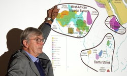 Ein Mann zeigt auf eine projizierte Karte, die historische afrikanische Reiche und Staaten darstellt.