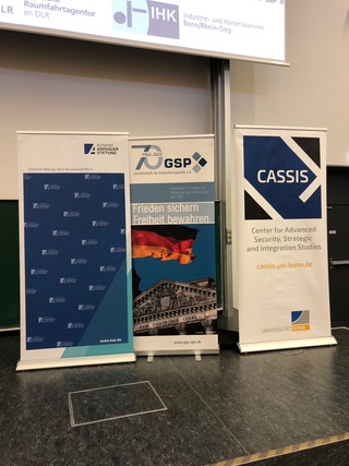 Drei Roll-ups von Konrad-Adenauer-Stiftung, GSP und CASSIS/Universität Bonn in einem Veranstaltungsraum.