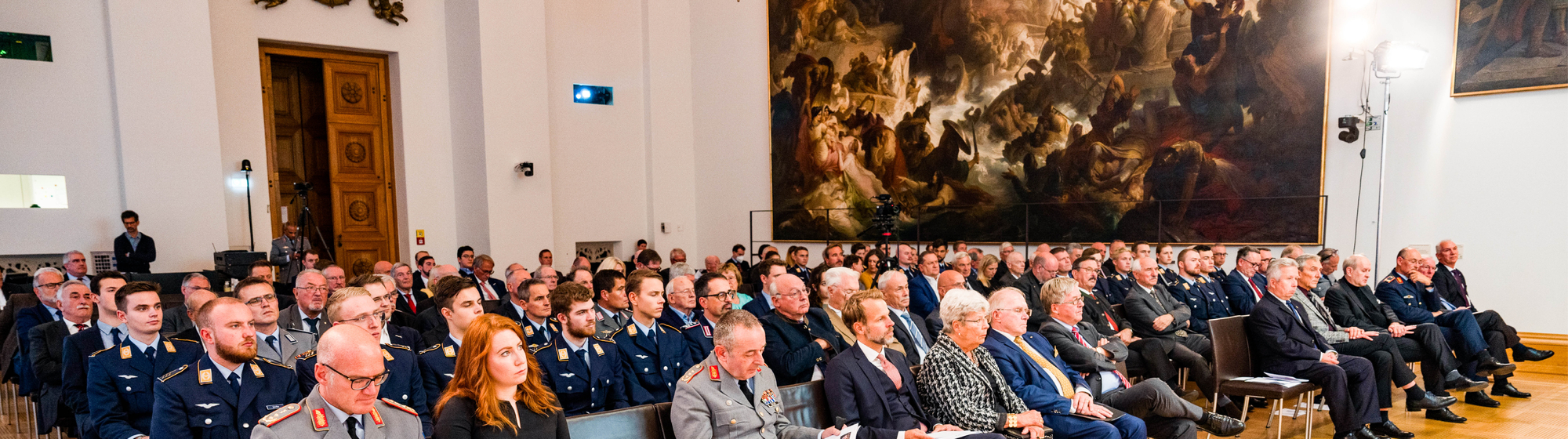 Publikum beim Festakt 70 Jahre GSP im Bayerischen Landtag München – Gäste in zivil und Bundeswehr-Uniform im historischen Festsaal mit großformatigem Gemälde