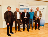 Fünf Männer posieren vor Bannern von Sicherheits- und deutsch-amerikanischen Organisationen.