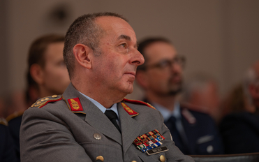 Nahaufnahme von General Breuer in deutscher Militäruniform, mit zahlreichen Orden, blickt bei einem Anlass nach rechts.