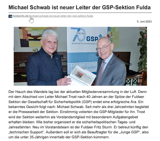 Zwei Männer, Michael Schwab und Michael Trost, lächeln und halten ein Dokument; ein GSP-Jubiläumsbanner ist im Hintergrund.