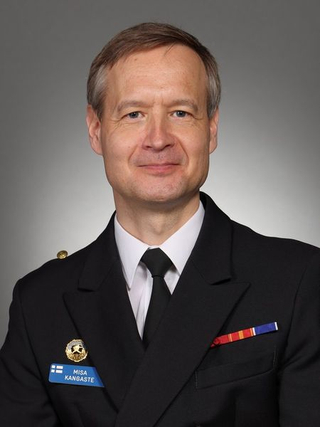 Porträt von Misa Kangaste, einem Mann in dunkler Militäruniform mit Namensschild (finnische Flagge) und Ordensband.