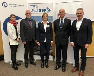 Fünf Personen lächeln vor Bannern der Friedrich Naumann Stiftung, GSP und Clausewitz-Gesellschaft.