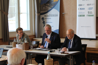 Was bedeutet nicht-lineare Kriegführung gegen Deutschland und Europa in Theorie und Praxis.  Mit dieser Frage beschäftigten sich Prof. Dr. Joachim Krause (r.) und Ferdinand Gehringer von FTI Consulting (l.). Dr. Olaf Theiler, Planungsamt der Bundeswehr, übernahm die Gesprächsleitung.