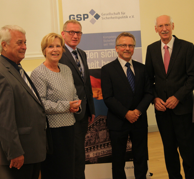 Fünf Personen, vier Männer und eine Frau, lächeln vor einem GSP-Banner der Gesellschaft für Sicherheitspolitik.