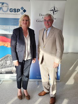 Eine blonde Frau und ein Mann in Anzug stehen vor Bannern der GSP und der Deutschen Atlantischen Gesellschaft.