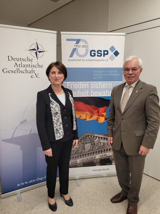 Eine Frau und ein Mann stehen zwischen zwei Bannern, einem der Deutschen Atlantischen Gesellschaft und einem der GSP.