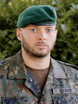 Porträt eines Bundeswehrsoldaten namens Kappe in Tarnuniform und grünem Barett, der den Betrachter ansieht.