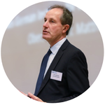 Dr. Hartwig von Schubert präsentiert auf der GDS 2012, trägt einen dunklen Anzug und eine blaue Krawatte.
