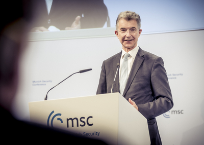 Ein lächelnder Mann im Anzug steht hinter einem Rednerpult mit dem Logo 'MSC Munich Security Conference'.