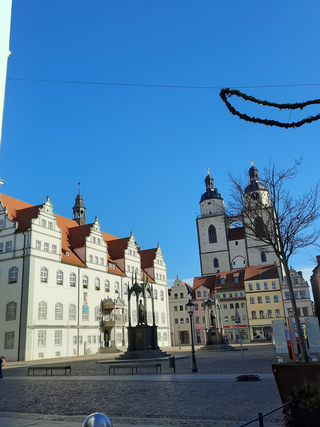 Historischer Marktplatz Wittenberg mit Rathaus, Stadtkirche St. Marien, Lutherdenkmal und festlicher Girlande.